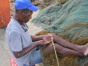 Pescador arranjando sua rede